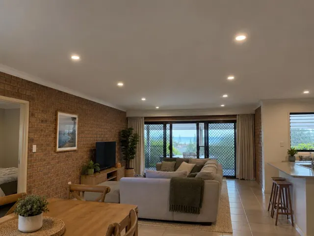 Living room with recessed downlights in a brick-walled home interior in Burleigh Heads